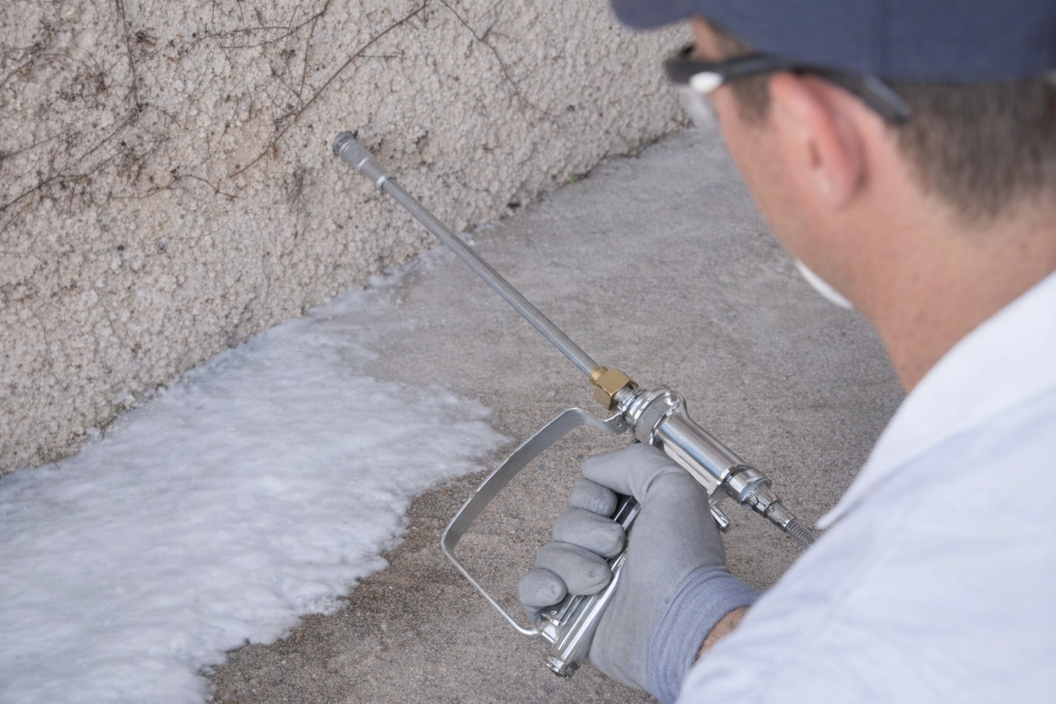 Professionnel appliquant un traitement chimique dans le sol contre les termites